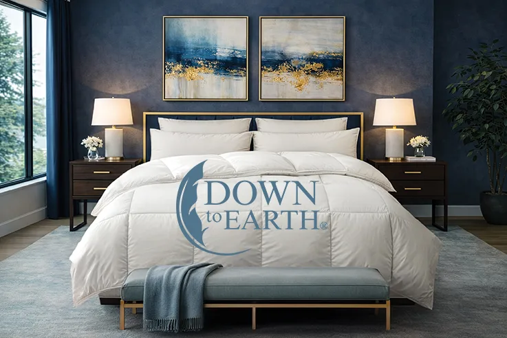 Cozy modern bedroom with a white comforter, two dark wood nightstands, lamps, and a large Down to Earth logo on the duvet.